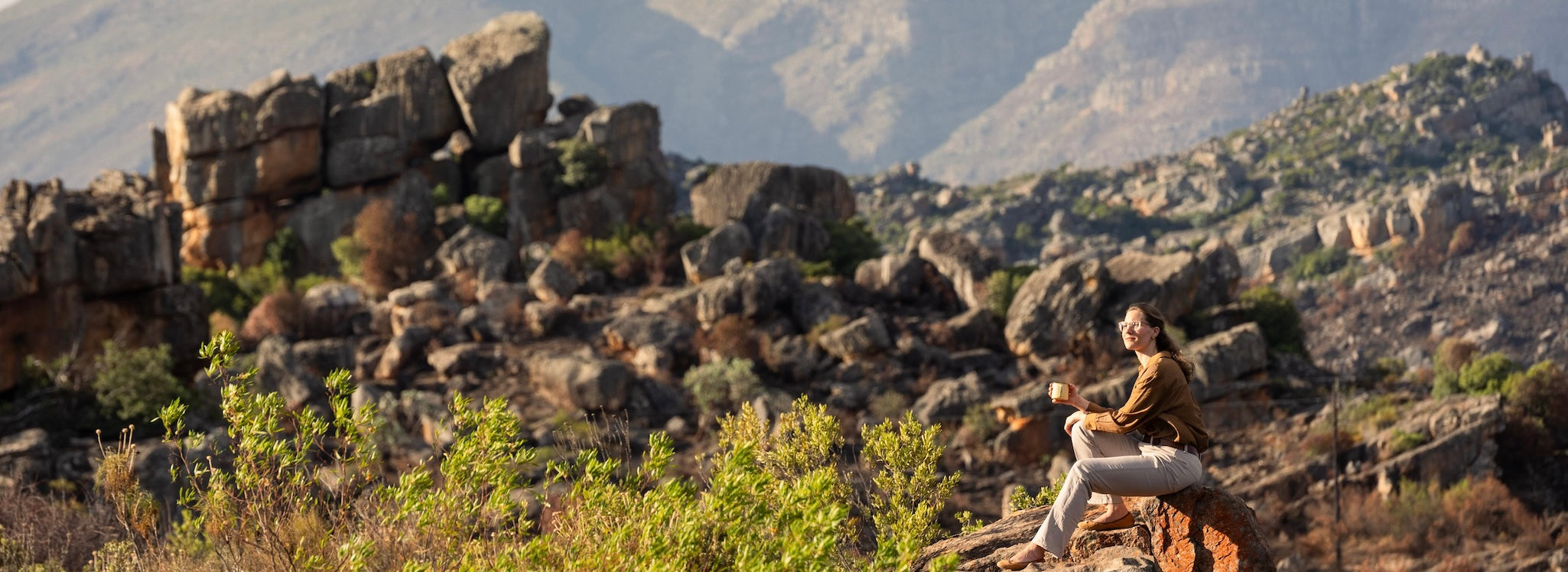 Cederberge Südafrika - Rooibesso-Gründerin Annette Güth mit Tasse Rooibos Espresso in den Bergen