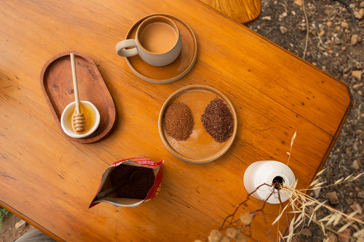Tisch mit Rooibos Espresso Tasse, Honig und red espresso. Braun, beige Farben.